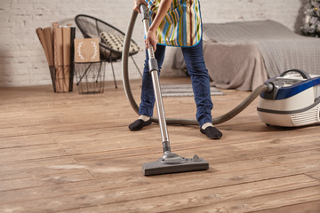 Cleaner vacuuming the floor in preparation for end-of-lease cleaning. Ensuring your home is spotless for inspection.