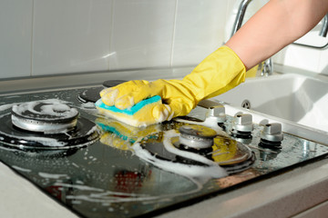 Cleaning stovetop during end of lease cleaning. Make sure kitchen appliances are spotless for inspection.