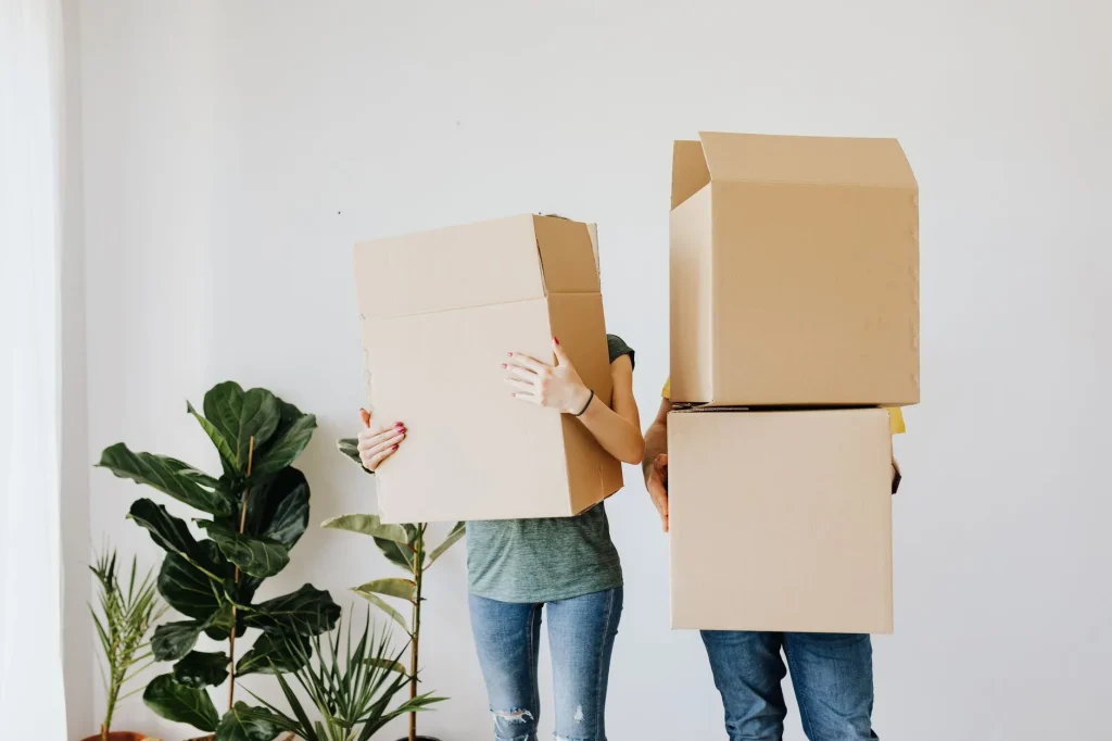 A couple prepares to move by packing their belongings into boxes.