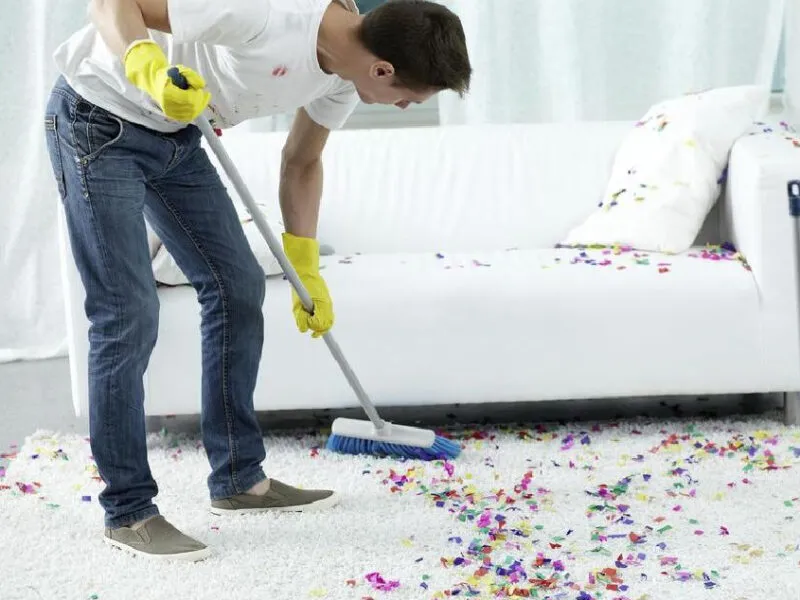 Is Bond Cleaning and End of Lease Cleaning Same? 8 A cleaner sweeps confetti off the carpet, preparing it for thorough bond and end-of-lease cleaning.
