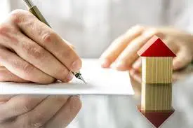 person signs a document related to a lease agreement, symbolizing the completion of end-of-lease formalities.