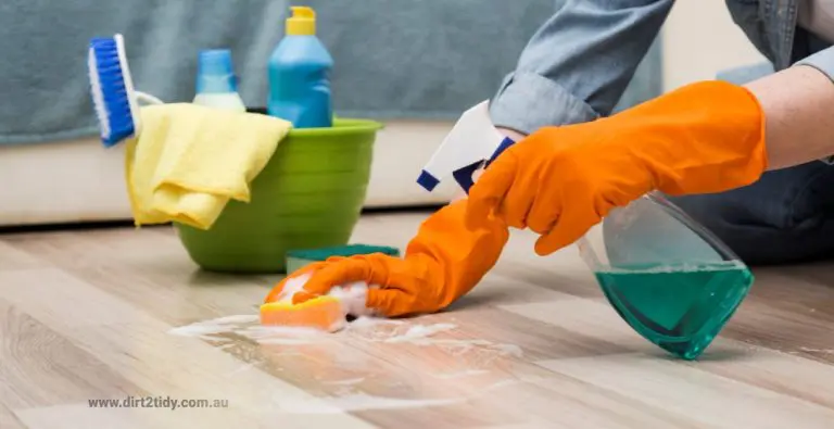 Person cleaning the floor with a sponge and cleaning supplies