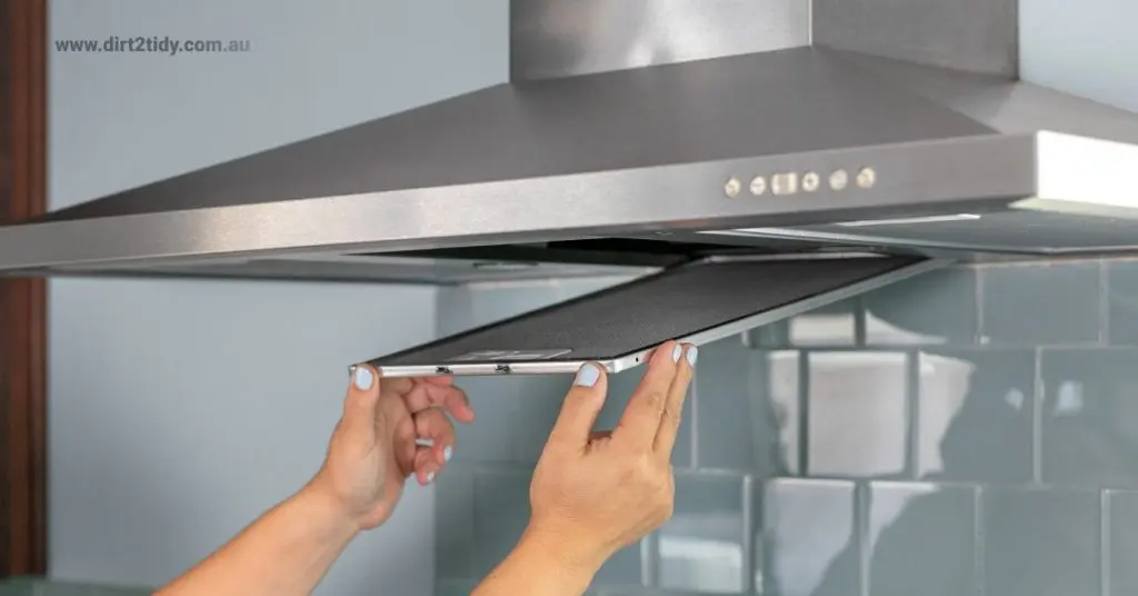 The Ultimate End of Lease Cleaning Checklist in 2025 6 Woman cleaning range hood filter in kitchen.