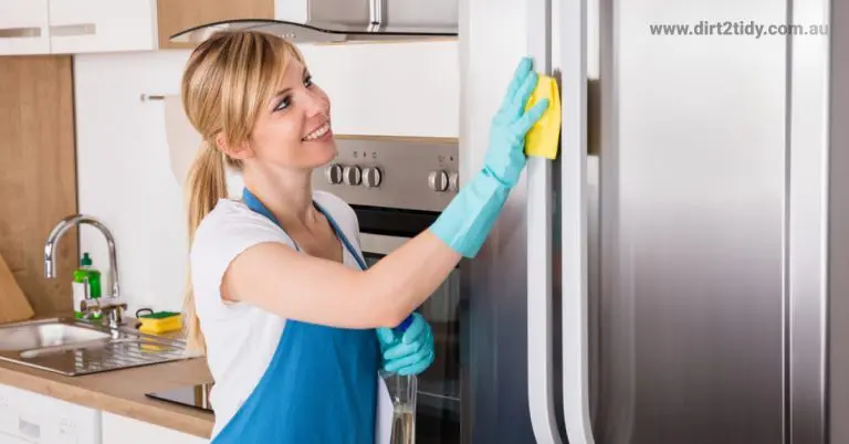 Woman cleaning the fridge with a yellow sponge