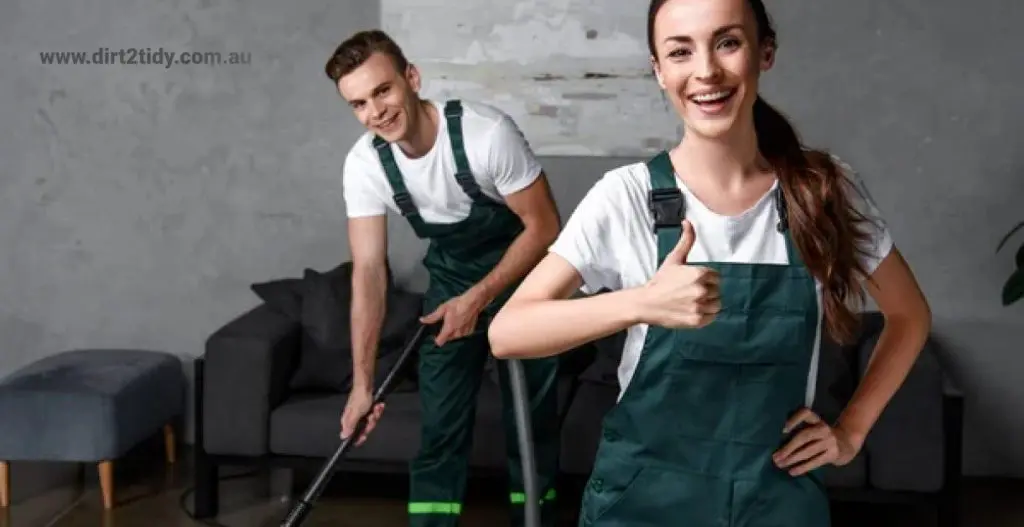 Two cleaners, one vacuuming and the other giving a thumbs up