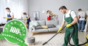 A group of professional cleaners tidying up a living room with a "100 percent bond back guaranteed" badge.