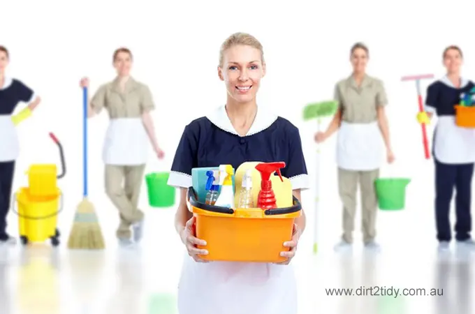  Close-up of a cleaner in gloves holding a green bucket filled with cleaning tools – symbolizing thorough home and office cleaning services by Dirt2Tidy.