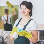 Female cleaner smiling with spray bottle