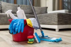 Who is the best end of lease cleaning in Randwick? 3 Cleaning bucket filled with gloves, spray bottles, cloths, mop, and sponges placed on a wooden floor – representing professional house cleaning essentials.