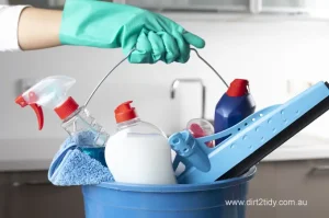 The best end of lease cleaning Botany 4 Blue bucket filled with cleaning sprays, liquids, and tools held by a gloved hand.