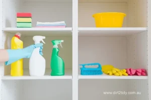 Common Mistakes to Avoid During End of Lease Cleaning in Eastern Suburbs: Insights from Dirt2Tidy 2 Organized cleaning products and gloves on white shelves.