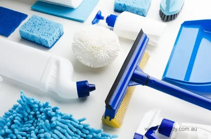 Top view of assorted cleaning tools in blue and white colors, including squeegees, brushes, sponges, bottles, and microfiber cloths – essentials for a spotless clean.

