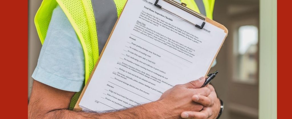  Person holding clipboard with a detailed home inspection checklist.