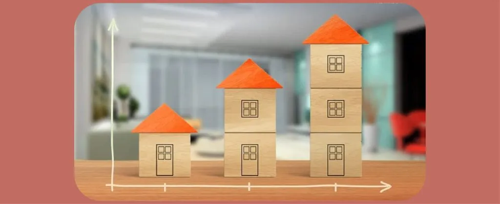 Wooden blocks stacked to represent growth, with a graph showing progress in real estate.